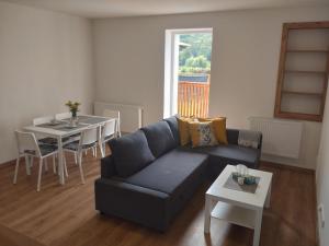 ein Wohnzimmer mit einem Sofa und einem Tisch in der Unterkunft Apartmán Karlovice - Jeseníky in Karlovice