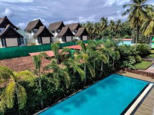 a view of a resort with a swimming pool at Ripples:Pool facing/RiverView/7 mins to Coco Beach in Nerul