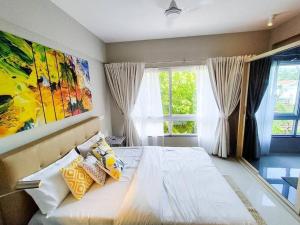 a bedroom with a bed with a painting on the wall at Ripples:Pool facing/RiverView/7 mins to Coco Beach in Nerul
