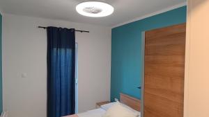 1 dormitorio con paredes azules y 1 cama con espejo en Mario, en Sukošan