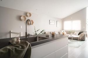 a kitchen with a sink and a living room at Arctic Homes - Unique Town House in Tromsø