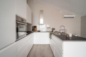 a white kitchen with white cabinets and a sink at ARCTIC HOMES - Unique Town House in Tromsø +14 photos