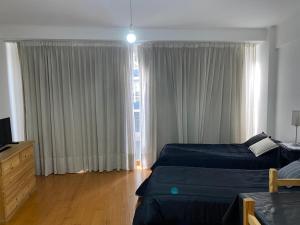 a bedroom with two beds and a large window at Monoambiente en Cañitas in Buenos Aires
