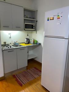 a kitchen with a white refrigerator and a sink at Monoambiente en Cañitas in Buenos Aires