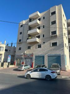 a white car parked in front of a building at Ghanem building 15 in Bethlehem