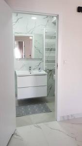 a white bathroom with a sink and a mirror at Apart 89A Angielska Grobla 5 - Gdańsk Śródmieście in Gdańsk
