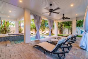 un patio avec des chaises et une piscine dans l'établissement Playa Esmeralda Vacation Home Up To 14 People, à Bradenton Beach