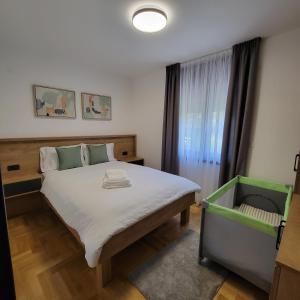 ein Schlafzimmer mit einem großen Bett und einem Fenster in der Unterkunft PIK Apartmani in Vrnjačka Banja