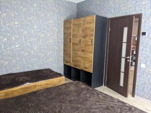 een slaapkamer met een bed en een houten kast bij Sundukyan Apartments in Gjoemri
