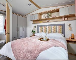 a bedroom with a large bed with a tray on it at Platinum Holiday Home by the Sea in Whitstable