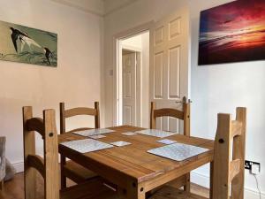 a wooden table and chairs in a dining room at Spacious 2-Bedroom House In Stockton Heath With Free WiFi By Amazing Spaces Relocations Ltd in Warrington