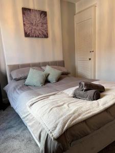 a bed with a cat laying on top of it at Spacious 2-Bedroom House In Stockton Heath With Free WiFi By Amazing Spaces Relocations Ltd in Warrington