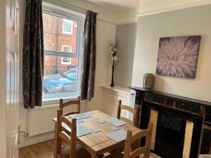 a dining room with a table and a fireplace at Spacious 2-Bedroom House In Stockton Heath With Free WiFi By Amazing Spaces Relocations Ltd in Warrington