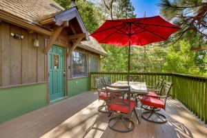 un patio con una mesa y una sombrilla roja en Crestline Getaway with Grill Less Than 1 Mi to Lake Gregory!, en Crestline