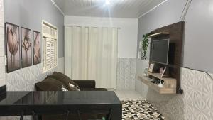 a living room with a couch and a television at CASA TEMPORADA PRADO-BA in Prado