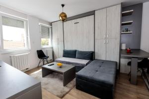 a living room with a couch and a table at Apartman Skver in Tuzla