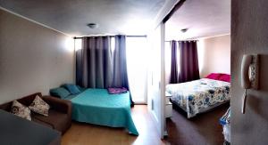 um quarto com duas camas e um sofá num quarto em Lindo Departamento Amoblado (Santiago) em Santiago