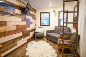 a living room with a couch and a wall of reclaimed wood at Teton Tiny Home in Victor