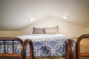 a bed with a blue and white comforter in a room at Teton Tiny Home in Victor