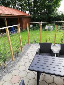 a patio with a table and chairs and a fence at Skovhusets B&B i Gislev in Gislev