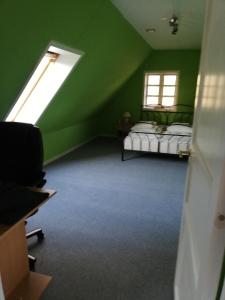 a green room with two beds and a window at Skovhusets B&B i Gislev in Gislev