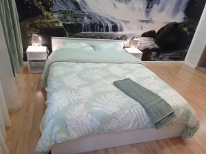1 dormitorio con 1 cama con un mural de cascada en Great location In Helsinki, en Helsinki