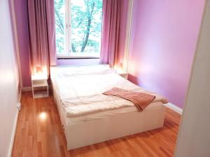 uma pequena cama num quarto com uma janela em Great location In Helsinki em Helsinque