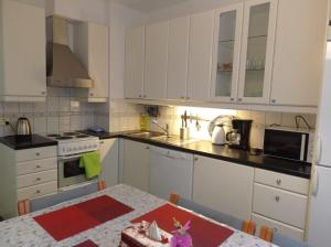 a kitchen with white cabinets and a table with a table sidx sidx at Great location In Helsinki in Helsinki