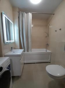 a bathroom with a toilet and a tub and a sink at Casa intr-o zona linistita in Bender