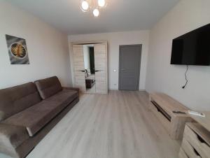 a living room with a couch and a flat screen tv at Casa intr-o zona linistita in Bender