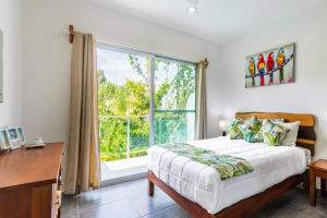 une chambre avec un lit et une grande fenêtre dans l'établissement Casa Alegria BY Sandy Powerful, à Tulum 27 autres photos