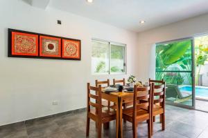 une salle à manger avec une table et des chaises en bois dans l'établissement Casa Alegria BY Sandy Powerful, à Tulum