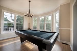 a pool table in a room with windows at Beautiful home near Marine Corps base in Jacksonville