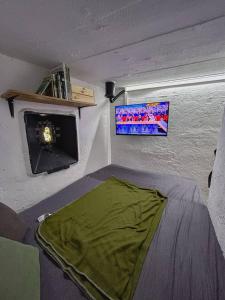 a room with a bed with a tv on the wall at Vojenský bunker in Bratislava