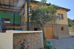 una casa con un árbol delante de ella en Ferme Dar Aicha green Bellouta, 