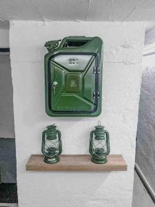 a shelf with two green vases on a wall at Vojenský bunker in Bratislava