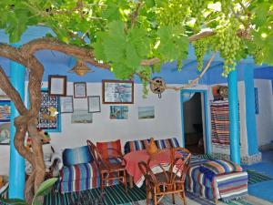 a living room with a table and chairs under a tree at Ferme Dar Aicha green Bellouta 