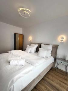 ein Schlafzimmer mit einem großen weißen Bett mit weißen Kissen in der Unterkunft Sika Sunny Garden Apartment in Arad