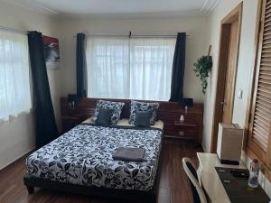 a bedroom with a bed with a black and white comforter at La Villa Saint Jean in Cotonou