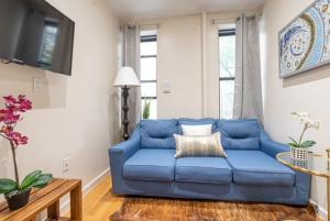 4BR in Amsterdam Ave في نيويورك: أريكة زرقاء موجودة في غرفة المعيشة