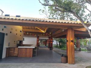 an outdoor kitchen with a wooden pergola at Praia do Forte - Villa do Lago in Praia do Forte
