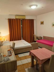 a room with two beds and a table and chairs at Lovely Home City Center in Mostar