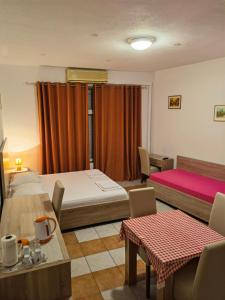 1 dormitorio con 2 camas, mesa y sillas en Lovely Home City Center en Mostar