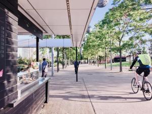 a man riding a bike down a street at Calm Zen Oasis, In Iconic London Olympic Park in London