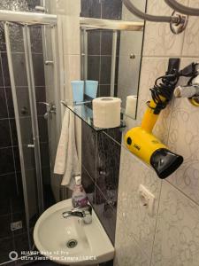 a bathroom with a sink and a yellow object on the wall at Lovely Home City Center in Mostar