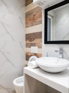 a white bathroom with a sink and a toilet at Tirana Central Apartments - Premium in Tirana