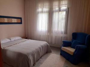 um quarto com uma cama, uma cadeira e uma janela em ÇobanEvi Gökçeada sakin,huzurlu... em Gokceada Town