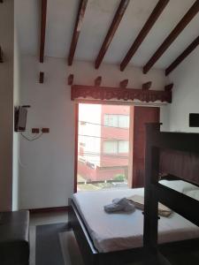 a bedroom with a bed and a window at Hotel Boutique Babilonia Manizales in Manizales