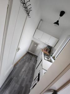 an attic kitchen with white cabinets and a staircase at FEE Apartment 1 Bremerhaven in Bremerhaven