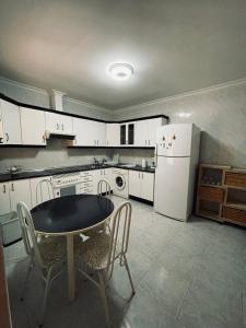 eine Küche mit einem Tisch und einem weißen Kühlschrank in der Unterkunft Casa de Tina y Cora in Mora